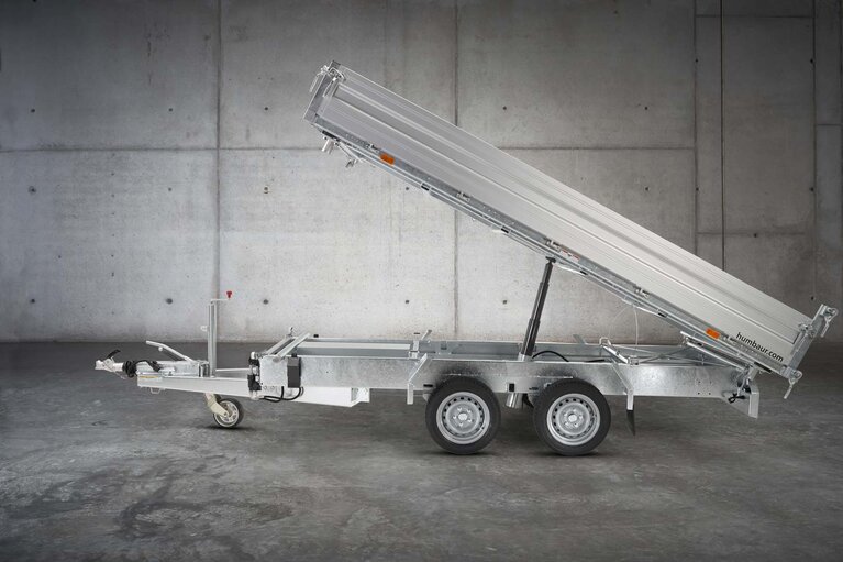 Un camion à benne basculante à deux essieux de couleur argentée