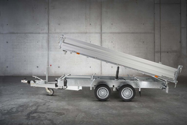 Un camion à benne basculante à deux essieux de couleur argentée